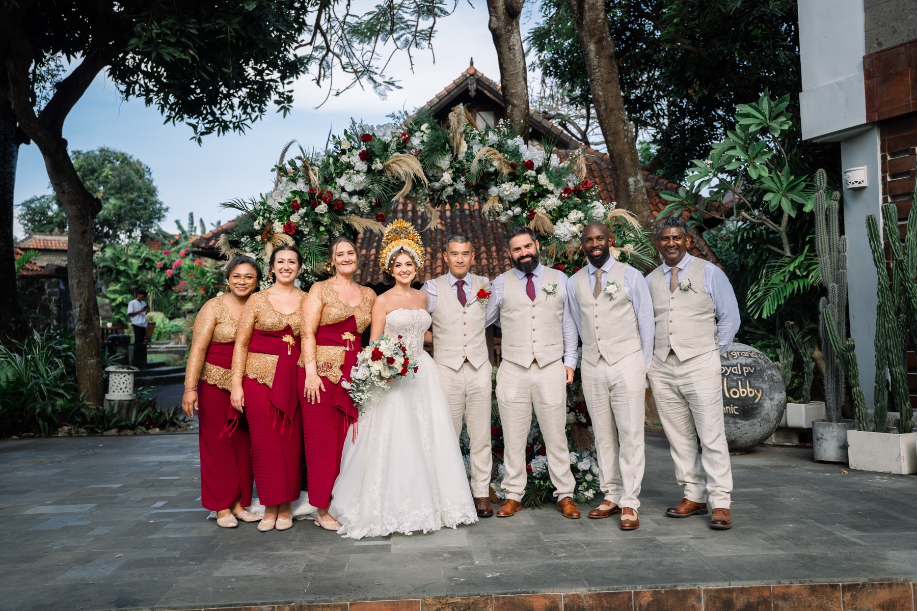 A wedding party at Alindra Villa in Jimbaran, standing under the traditional Balinese roofs and tropical garden of the resort
