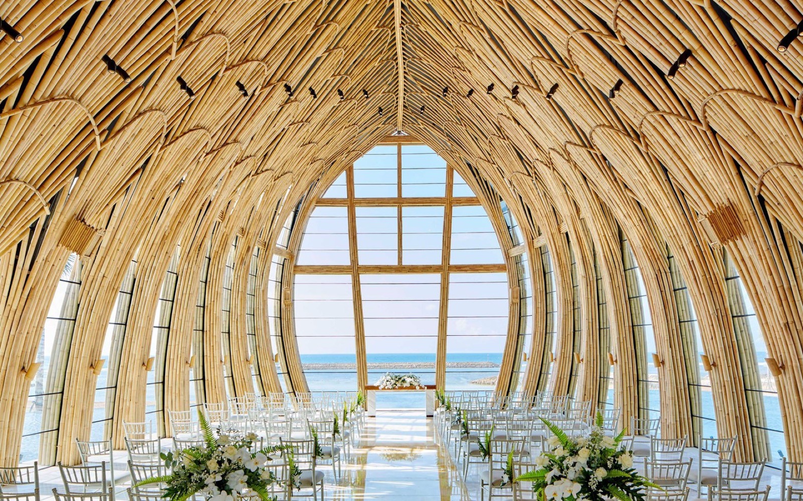 The glass-fronted Apurva Chapel at The Apurva Kempinski Bali in Nusa Dua, framed by water with the Indian Ocean beyond