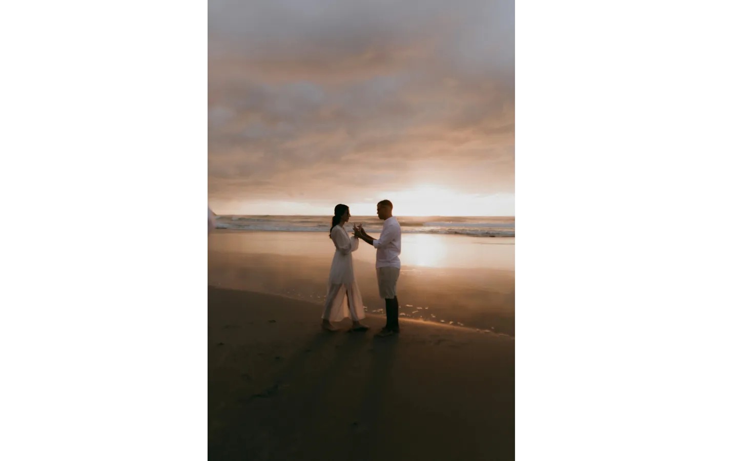 Couple on the beach at sunset at Bali Beach Glamping on the west coast of Tabanan, near Tanah Lot