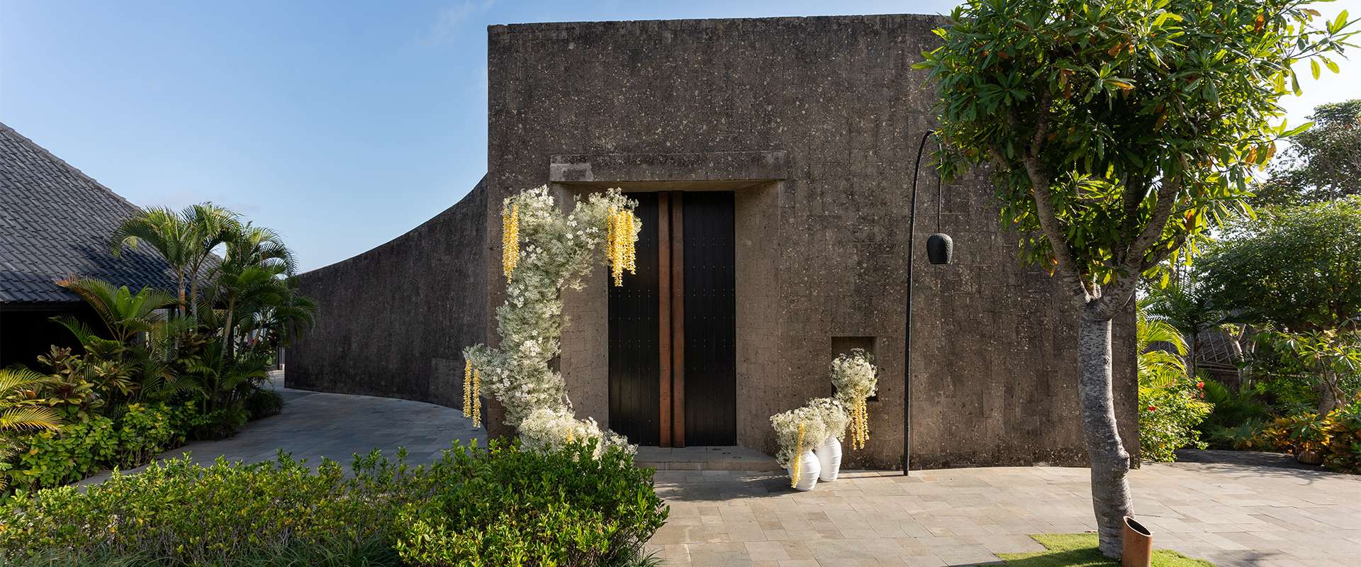 The glass-walled Bvlgari wedding chapel at Bulgari Resort Bali on the Uluwatu cliff, with the Indian Ocean beyond
