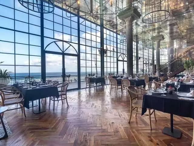 Glass-walled dining room at Canna Bali facing the ocean in Nusa Dua