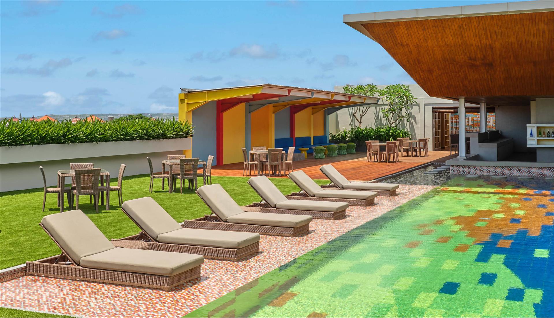 Rooftop pool with garden lawn, loungers, and cabana at Fairfield by Marriott Bali South Kuta