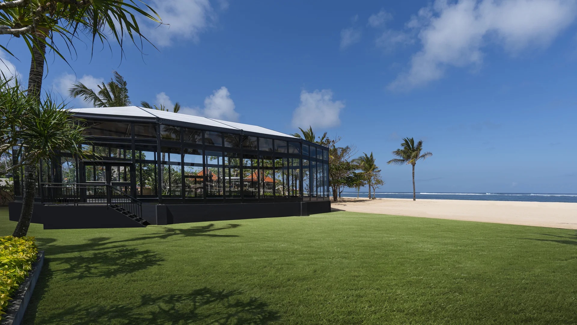 Interior of the Glass House at The Mulia set for a wedding, glass walls facing the ocean