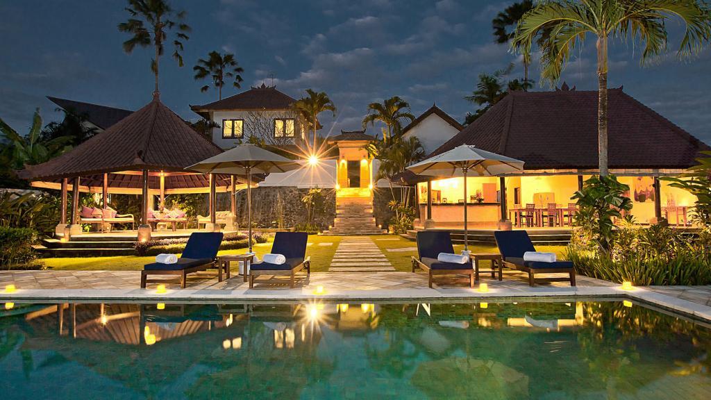 The Junno Villa's pool and garden pavilions surrounded by rice fields in Padonan, Canggu