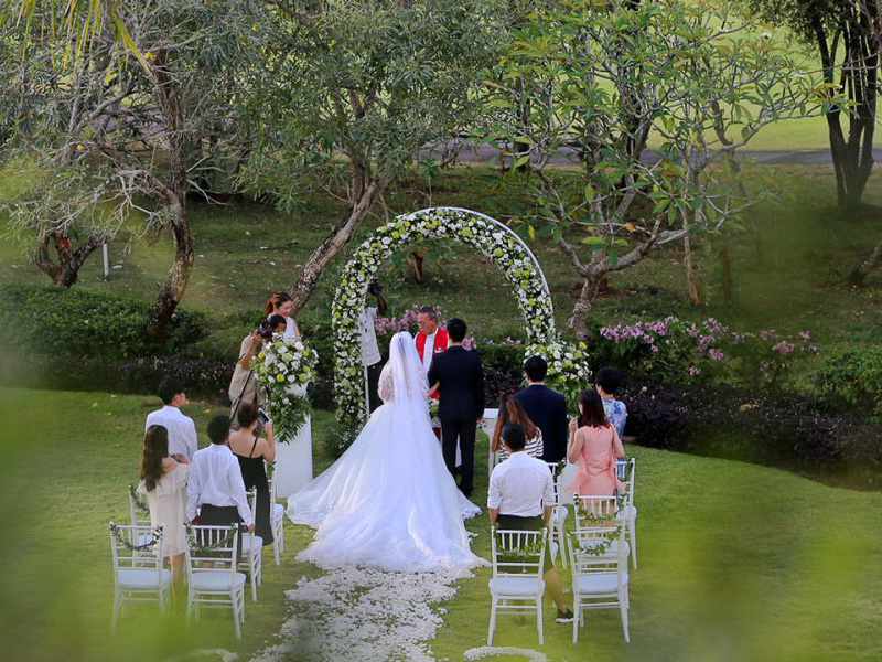 Garden wedding setup at Le Grande Bali Uluwatu, with lawn, trees, and a decorated ceremony area