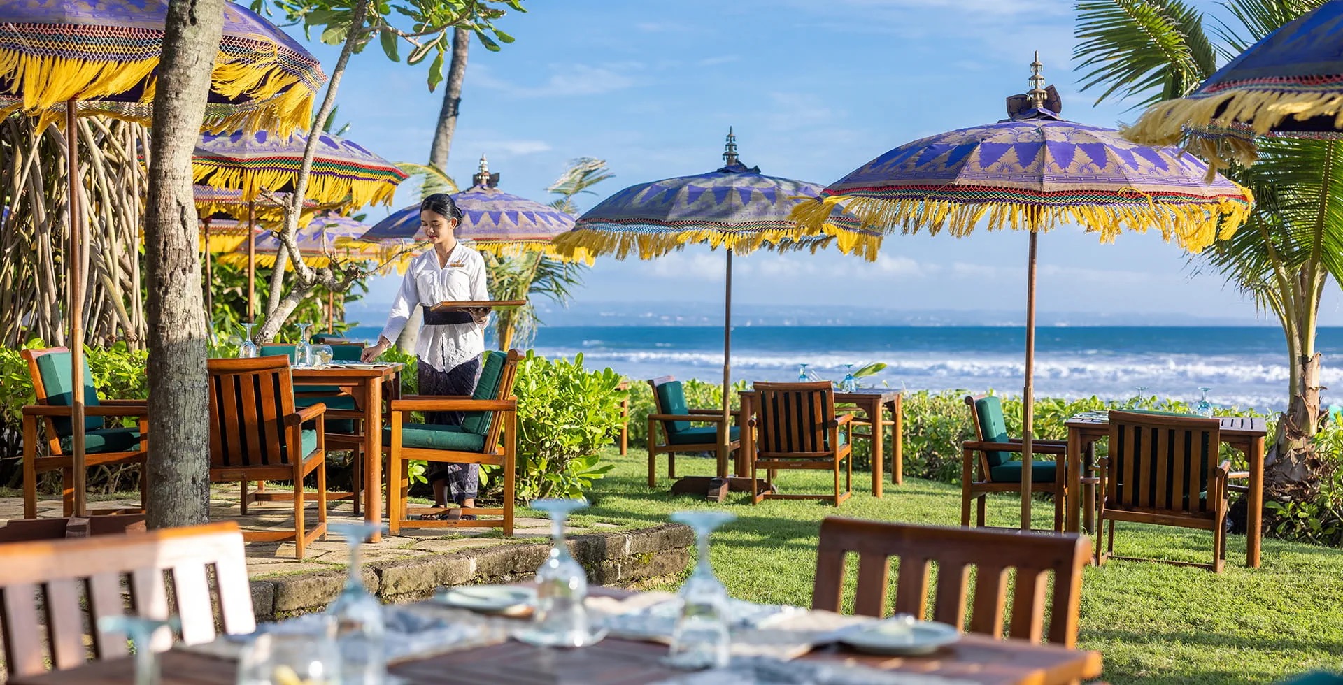 The oceanfront grounds of The Oberoi Beach Resort Bali on Seminyak Beach at dusk