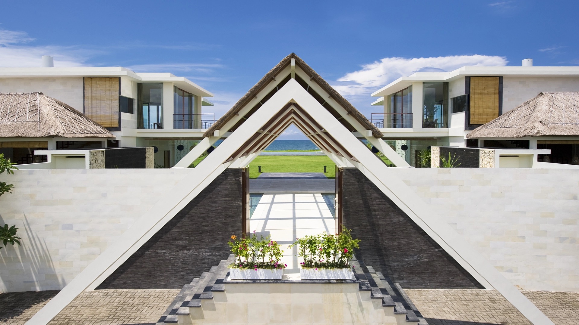 Phalosa Villa's beachfront lawn and pool on Batu Belig Beach in greater Seminyak, the Indian Ocean beyond