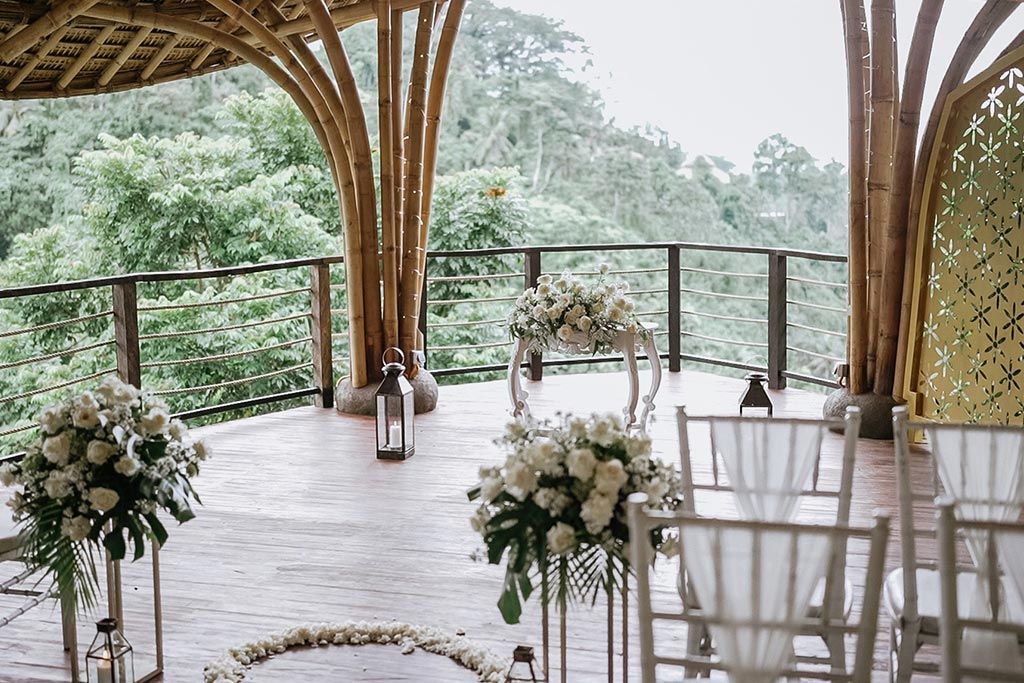 The Puspaka Sky Wedding Chapel at The Kayon Valley Resort, a bamboo pavilion deck set with white florals and lanterns, overlooking jungle valley near Ubud