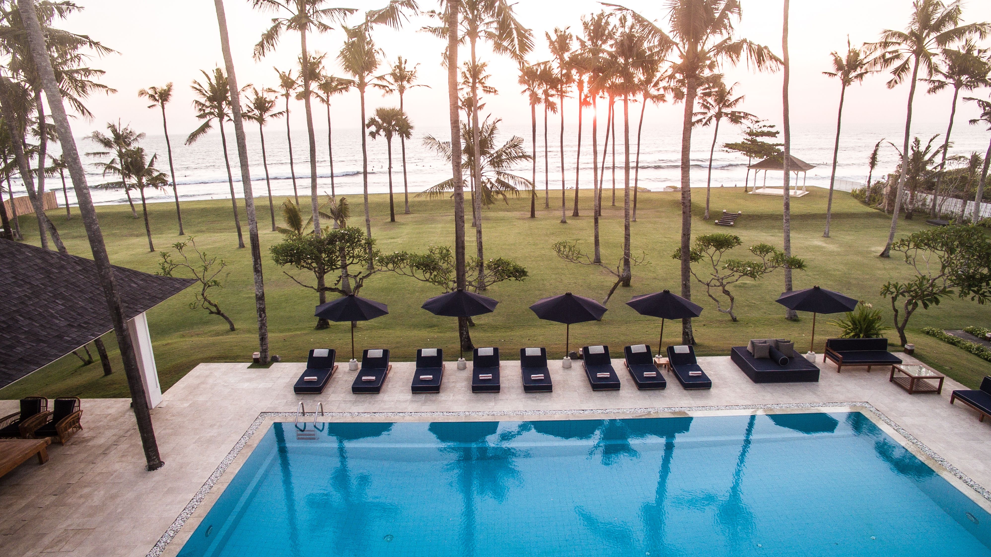 Semara Beach House's beachfront lawn and pool facing the Indian Ocean on Berawa Beach in Canggu