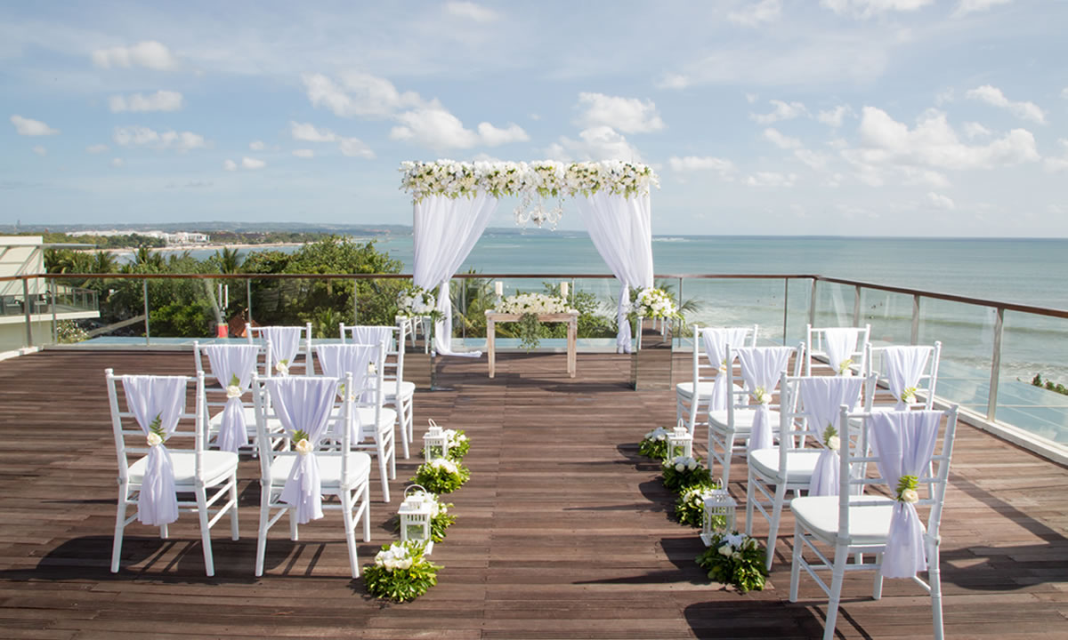 The Bene rooftop wedding deck at Sheraton Bali Kuta Resort, set for a ceremony above Kuta Beach at sunset