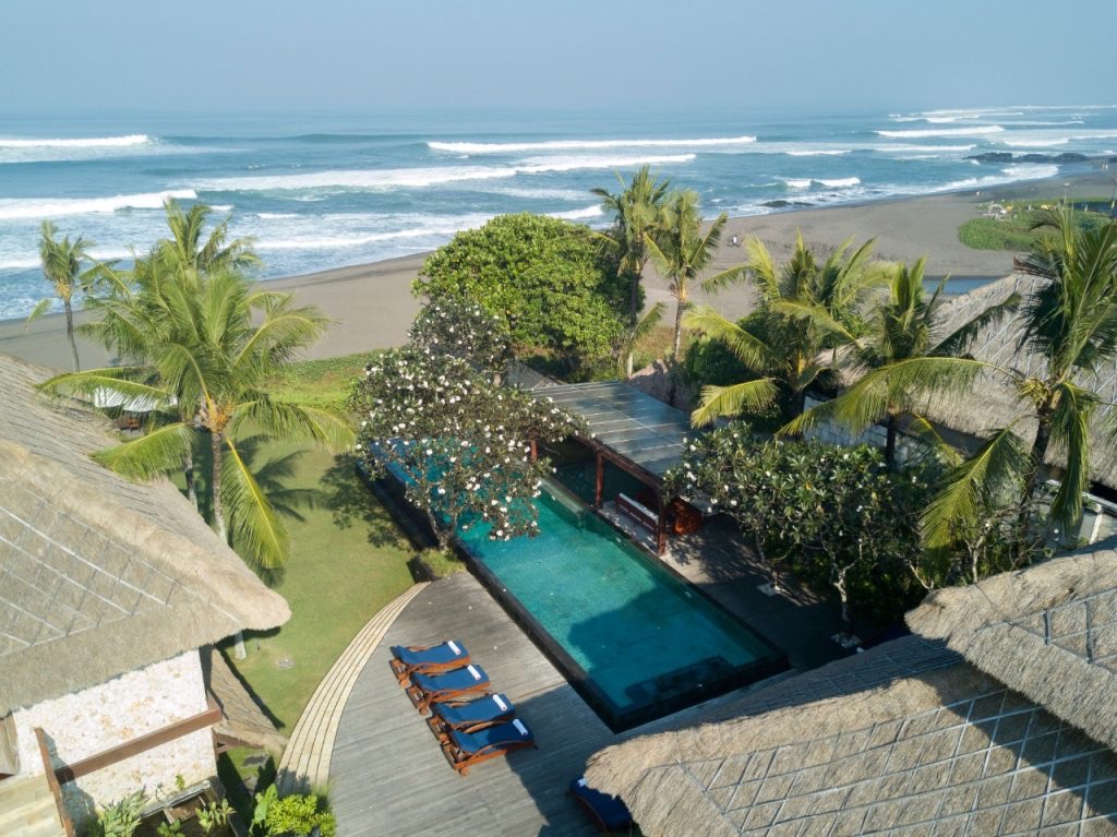 Aerial view of Sound of the Sea villa on the beachfront at Pererenan, Canggu, with its infinity pool, gardens, and the ocean beyond