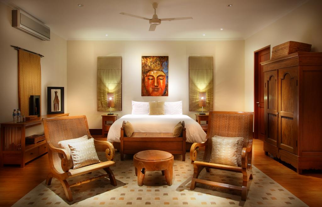 Teakwood bedroom at Villa Ali Agung with a king bed and a Buddha painting above the headboard