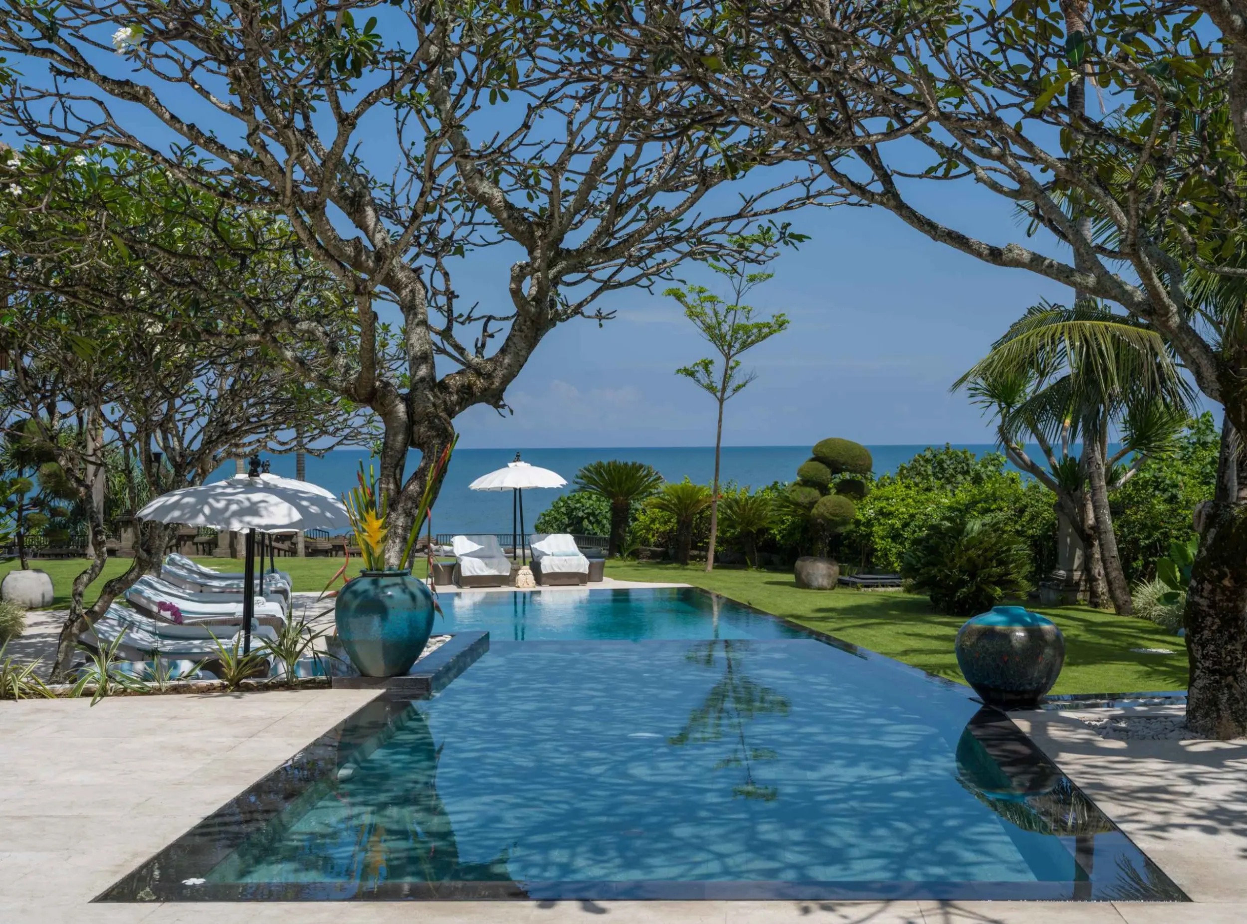 Villa Ambra's infinity pool and gardens looking out to the beach at Pererenan, Canggu, in the Pantai Lima estate