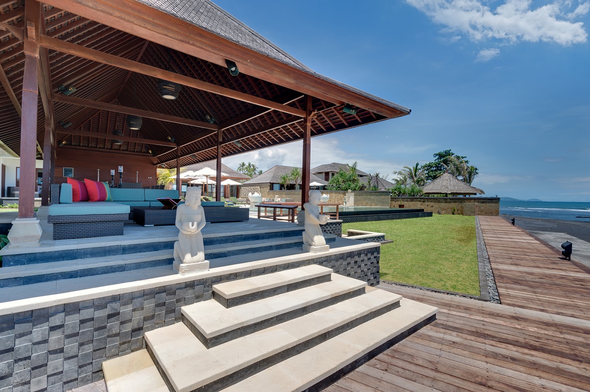 The outdoor deck at Villa Bayu Gita, furnished with beach lounge chairs and ottomans