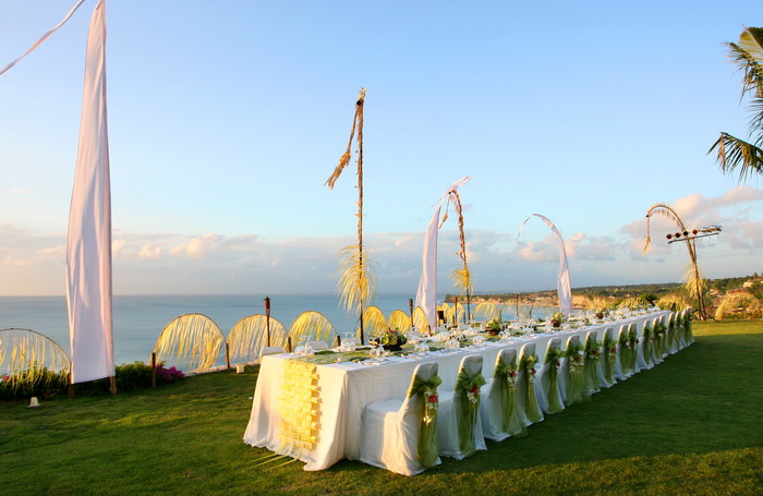 Long reception table set for a wedding dinner on the clifftop lawn at Villa Bayuh Sabbha