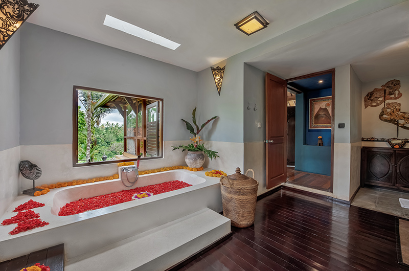 Ensuite bathroom at Villa Bodhi with a petal-filled bathtub beside a garden-view window