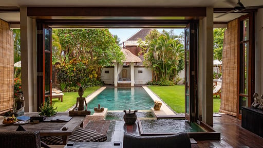 The pool and walled garden at Villa Majapahit Nataraja, viewed through the open living pavilion
