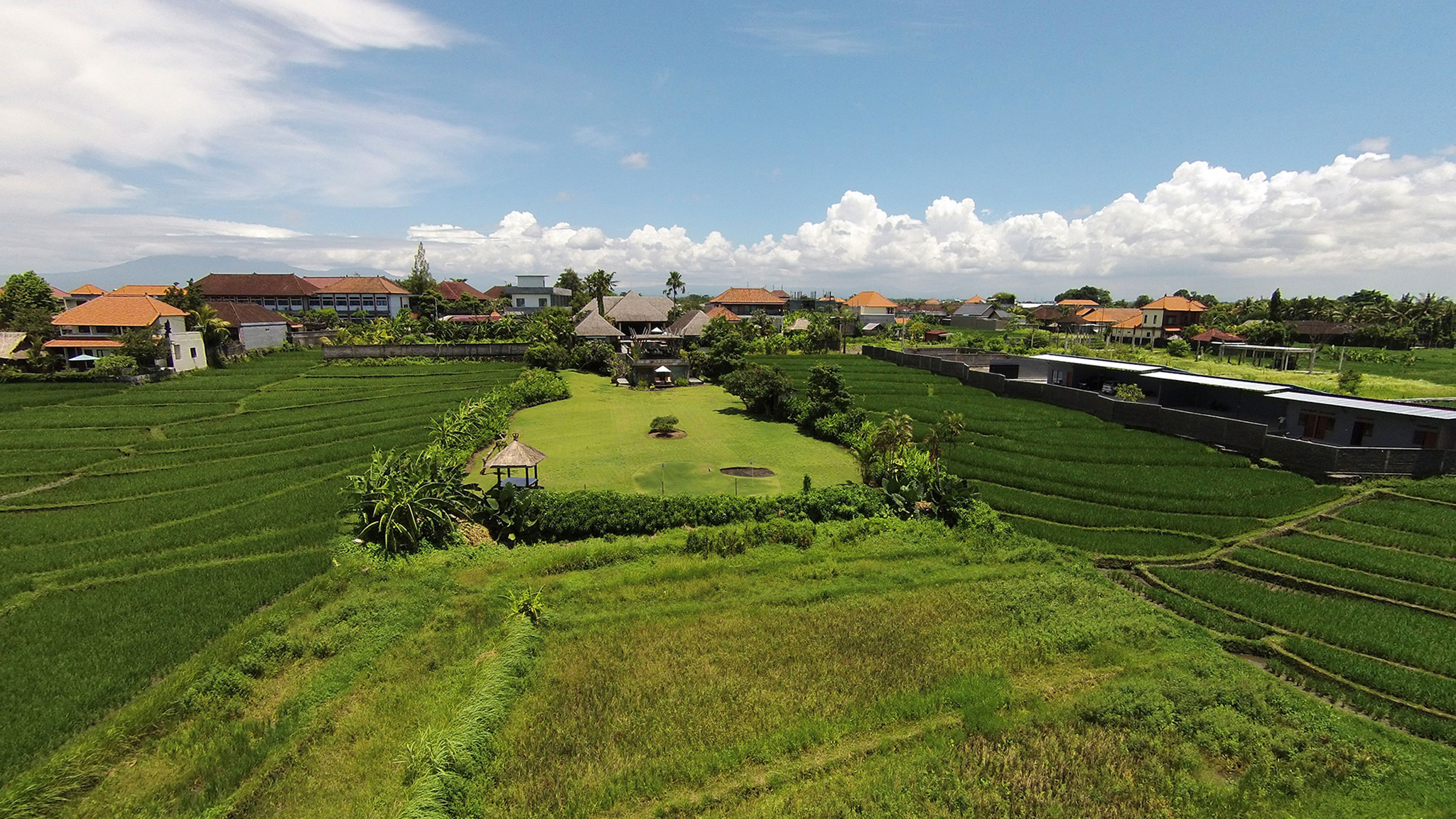Aerial view of Villa Mandalay among rice fields near Seseh, west Bali, with the Indian Ocean beyond