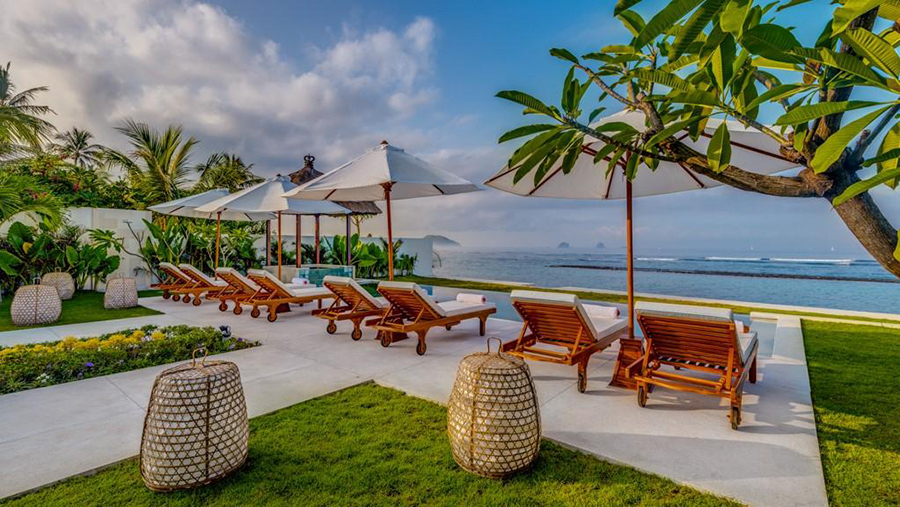 Sun loungers and umbrellas along Villa Oceana's pool deck, facing the open sea