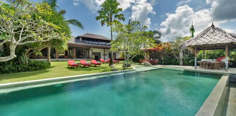 Villa Paloma's infinity pool and tropical garden on a riverside estate in Canggu