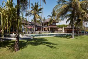 Study at Villa Pushpapuri with a timber desk and louvred windows opening to the rice fields