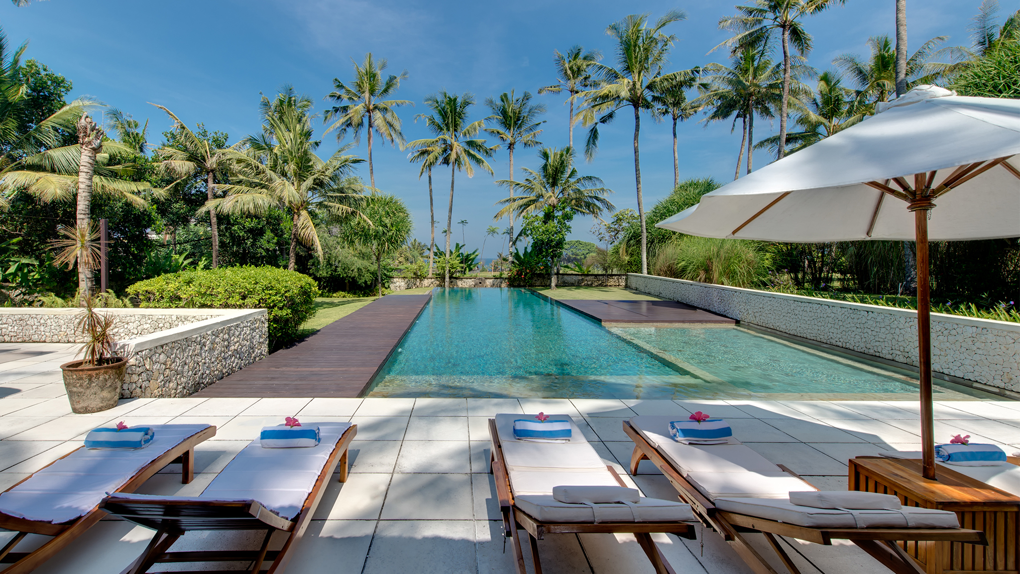 The open-air dining pavilion at Villa Samadhana, with a high vaulted timber ceiling and a long solid-wood table