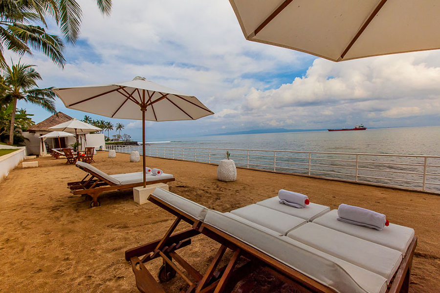 Sun loungers and umbrellas on Villa Stella's private beach, overlooking Amuk Bay