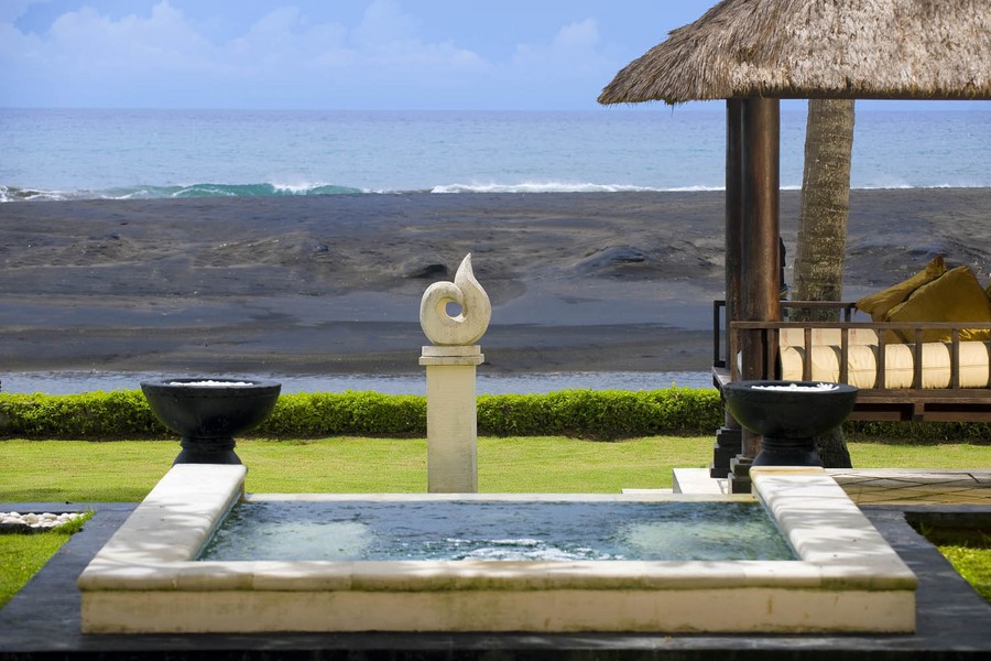 Pool and fountain facing the beach and a thatched gazebo at Villa Ylang Ylang